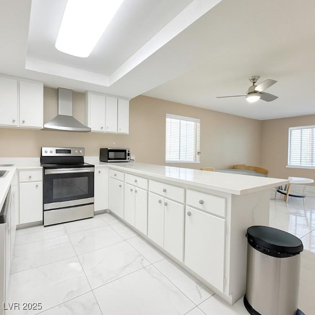 4420 Rich Dr Unit B, Las Vegas, NV 89102 - kitchen featuring stainless steel electric range, wall chimney range hood, a peninsula, light countertops, and light marble finish flooring