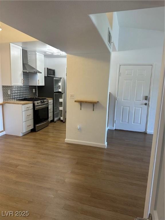 7885 W Flamingo Rd Unit 2129, Las Vegas, NV 89147 - kitchen featuring appliances with stainless steel finishes, wall chimney exhaust hood, white cabinetry, and dark wood finished floors