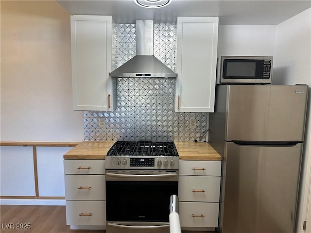 7885 W Flamingo Rd Unit 2129, Las Vegas, NV 89147 - kitchen featuring stainless steel appliances, wall chimney exhaust hood, butcher block counters, and tasteful backsplash