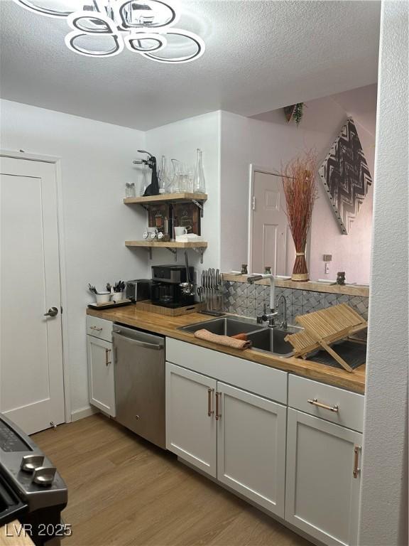 7885 W Flamingo Rd Unit 2129, Las Vegas, NV 89147 - kitchen with dishwasher, light wood-type flooring, a textured ceiling, open shelves, and butcher block countertops