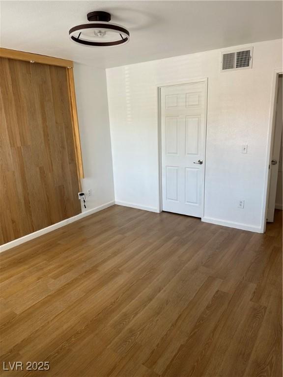 7885 W Flamingo Rd Unit 2129, Las Vegas, NV 89147 - unfurnished bedroom featuring baseboards and wood finished floors
