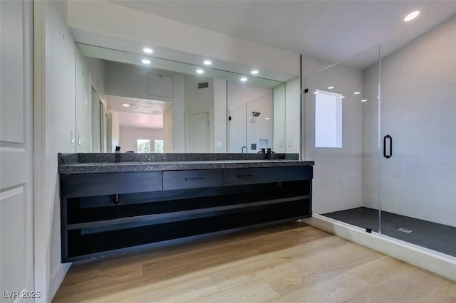 7132 Mission Hills Dr, Las Vegas, NV 89113 - bathroom featuring double vanity, wood finished floors, a shower stall, and recessed lighting