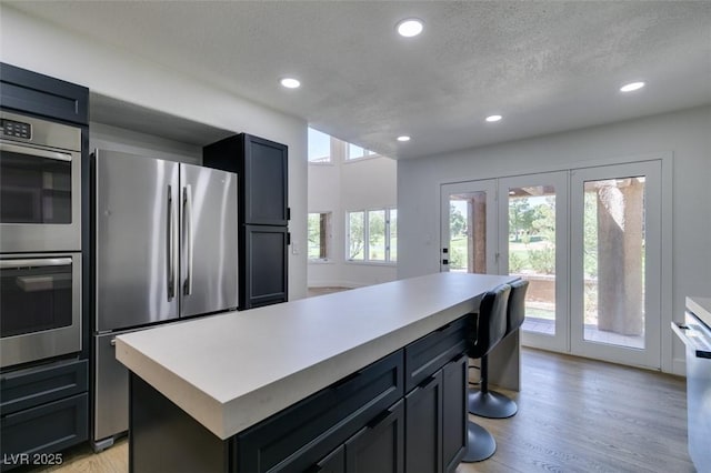 7132 Mission Hills Dr, Las Vegas, NV 89113 - kitchen featuring stainless steel appliances, recessed lighting, light countertops, a textured ceiling, and french doors
