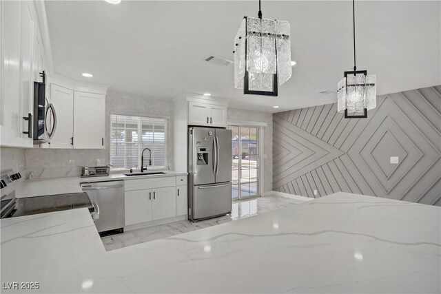 4490 W Warm Springs Rd, Las Vegas, NV 89118 - kitchen featuring stainless steel appliances, light marble finish flooring, plenty of natural light, light stone counters, and recessed lighting