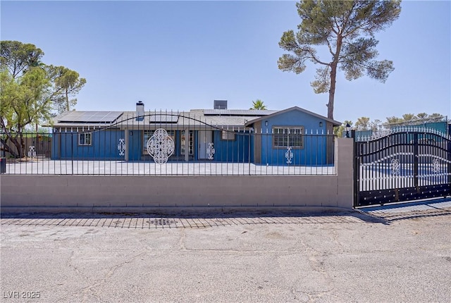 4490 W Warm Springs Rd, Las Vegas, NV 89118 - view of front of property with a fenced front yard, roof mounted solar panels, and a gate