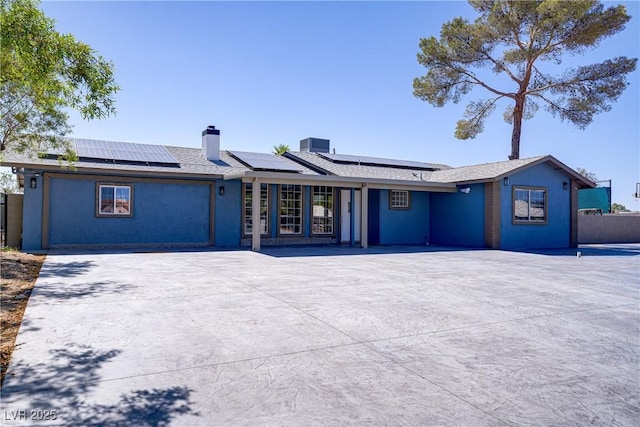 4490 W Warm Springs Rd, Las Vegas, NV 89118 - view of front facade with roof mounted solar panels and a chimney