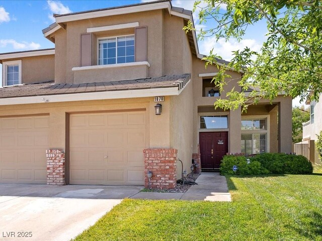 1870 Desert Forest Way, Henderson, NV 89012 - townhome / multi-family property featuring stucco siding, a front lawn, and an attached garage