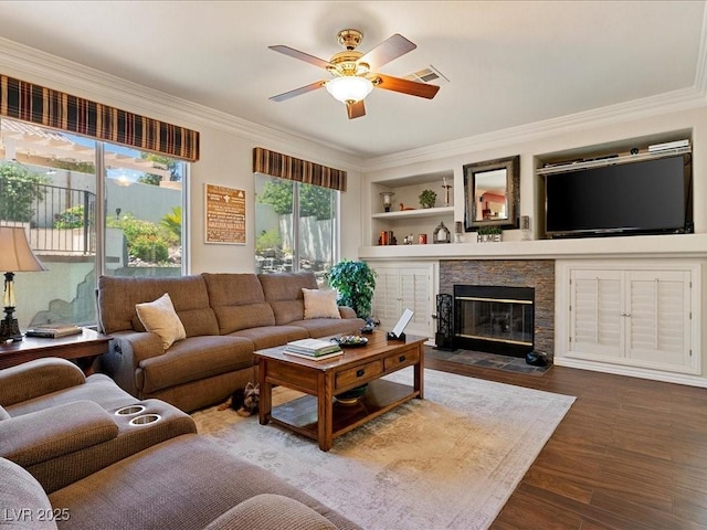 1870 Desert Forest Way, Henderson, NV 89012 - living area with ceiling fan, a stone fireplace, wood finished floors, crown molding, and built in shelves
