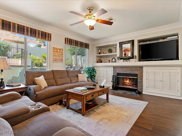 1870 Desert Forest Way, Henderson, NV 89012 - living room with ceiling fan, a stone fireplace, dark wood-type flooring, crown molding, and built in features