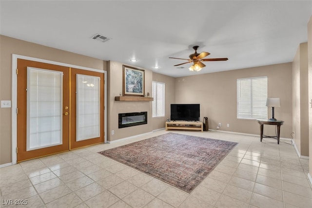 7720 Leavorite Dr, Las Vegas, NV 89128 - unfurnished living room with light tile patterned flooring, ceiling fan, french doors, and a fireplace