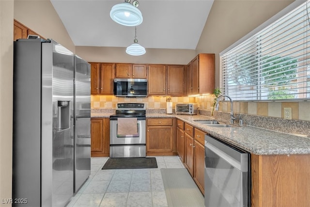 7720 Leavorite Dr, Las Vegas, NV 89128 - kitchen featuring appliances with stainless steel finishes, brown cabinets, tasteful backsplash, vaulted ceiling, and light stone counters