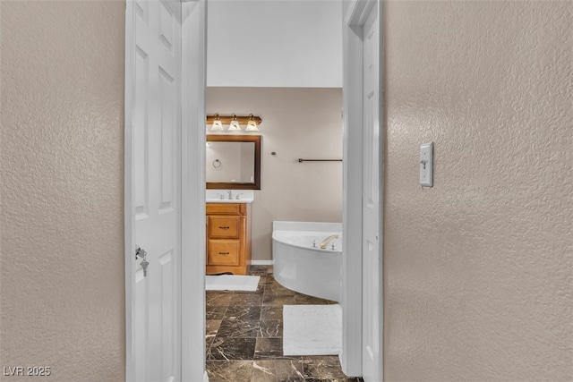 7720 Leavorite Dr, Las Vegas, NV 89128 - full bathroom featuring a freestanding bath, vanity, marble finish flooring, and a textured wall