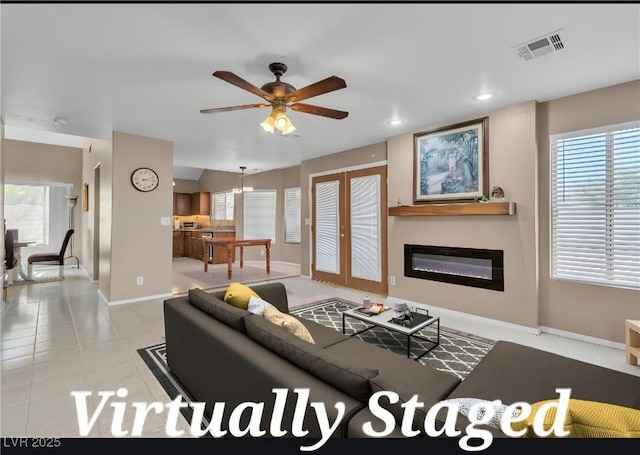 7720 Leavorite Dr, Las Vegas, NV 89128 - living room with ceiling fan, french doors, light tile patterned flooring, a glass covered fireplace, and recessed lighting