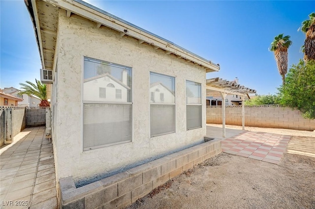 1950 Turtlerock St, Las Vegas, NV 89142 - view of side of home with a patio area, stucco siding, and a fenced backyard