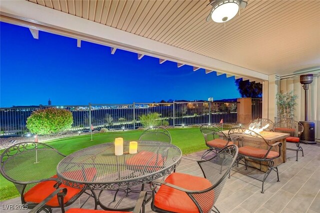 10621 Tinta Ln, Las Vegas, NV 89144 - patio at twilight featuring outdoor dining space, a patio, a fenced backyard, and a putting green