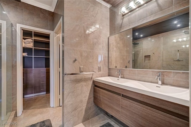 10621 Tinta Ln, Las Vegas, NV 89144 - bathroom with tile walls, a stall shower, double vanity, crown molding, and a walk in closet