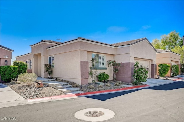 10621 Tinta Ln, Las Vegas, NV 89144 - view of front of property with an attached garage, stucco siding, and driveway