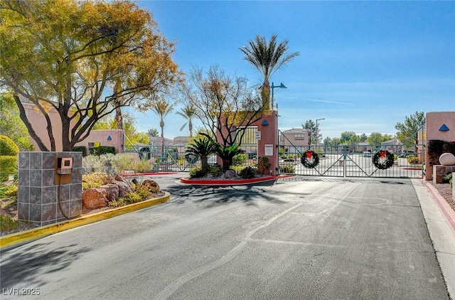 10621 Tinta Ln, Las Vegas, NV 89144 - view of asphalt street featuring a gate, a gated entry, curbs, and street lights