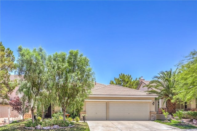 1869 Desert Forest Way, Henderson, NV 89012 - view of property hidden behind natural elements featuring a garage, concrete driveway, a tiled roof, and stucco siding