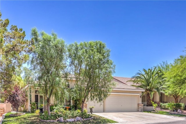 1869 Desert Forest Way, Henderson, NV 89012 - view of property hidden behind natural elements with driveway, an attached garage, and stucco siding