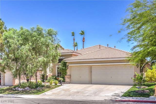 1869 Desert Forest Way, Henderson, NV 89012 - view of front of home with an attached garage, driveway, stucco siding, brick siding, and a tile roof