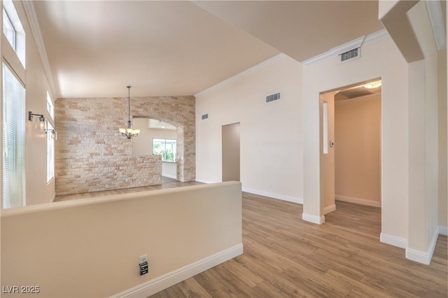 1869 Desert Forest Way, Henderson, NV 89012 - unfurnished room with vaulted ceiling, arched walkways, wood finished floors, a chandelier, and ornamental molding