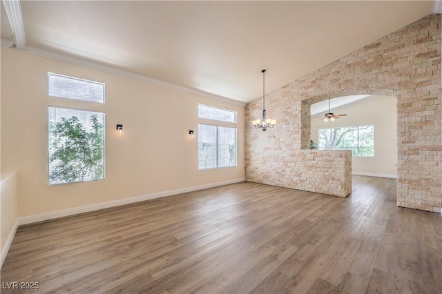 1869 Desert Forest Way, Henderson, NV 89012 - unfurnished living room with a chandelier, vaulted ceiling, wood finished floors, ceiling fan, and ornamental molding