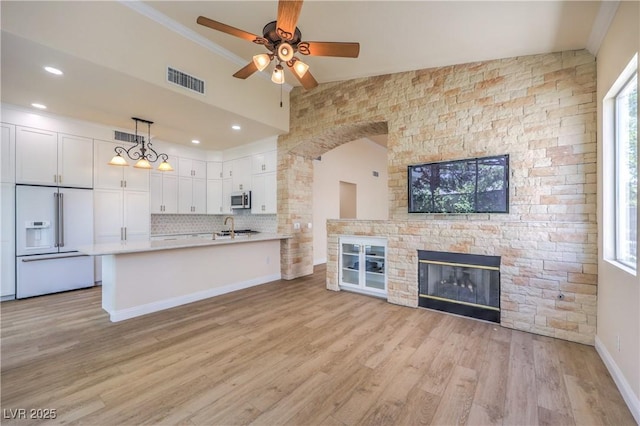 1869 Desert Forest Way, Henderson, NV 89012 - kitchen featuring white built in fridge, stainless steel microwave, white cabinetry, ceiling fan, and light countertops