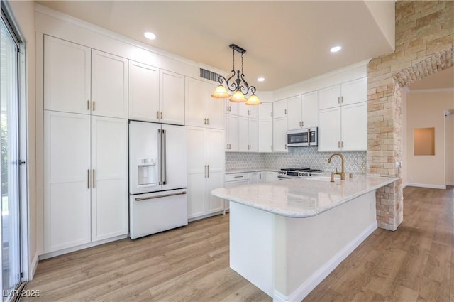1869 Desert Forest Way, Henderson, NV 89012 - kitchen featuring white built in refrigerator, stainless steel microwave, white cabinetry, light wood-style floors, and light stone countertops