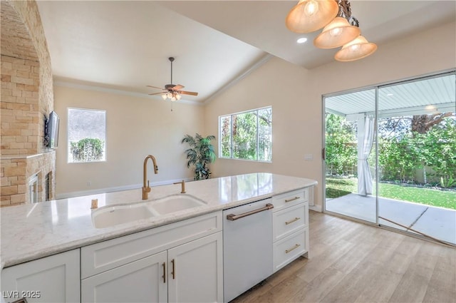 1869 Desert Forest Way, Henderson, NV 89012 - kitchen with white dishwasher, healthy amount of natural light, white cabinetry, lofted ceiling, and light stone countertops