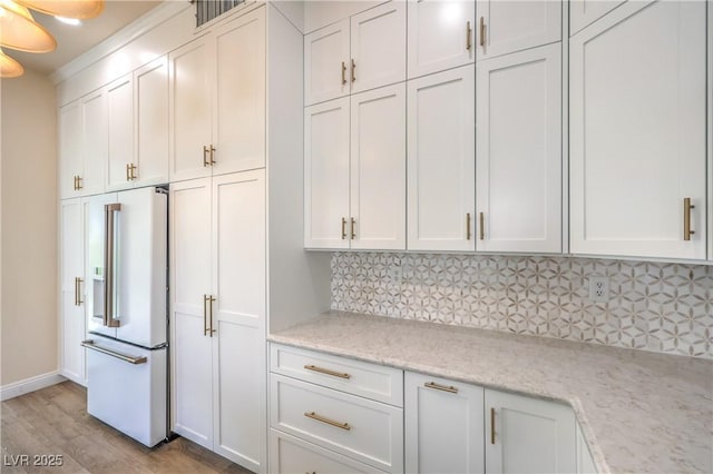 1869 Desert Forest Way, Henderson, NV 89012 - kitchen featuring high end white refrigerator, backsplash, light wood finished floors, and white cabinets