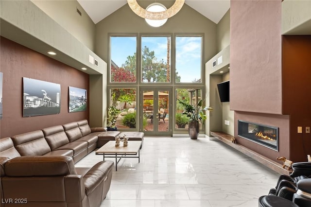 3004 Astoria Pines Cir, Las Vegas, NV 89107 - living room featuring high vaulted ceiling, marble look tile flooring, a glass covered fireplace, and french doors