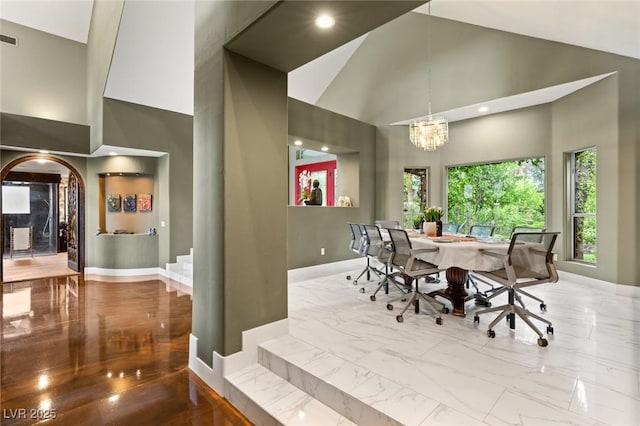 3004 Astoria Pines Cir, Las Vegas, NV 89107 - dining area featuring high vaulted ceiling, a chandelier, marble finish flooring, arched walkways, and recessed lighting