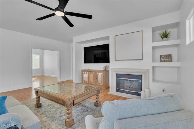 11253 Revelry Ln, Las Vegas, NV 89138 - living room featuring wood finished floors, a glass covered fireplace, and ceiling fan