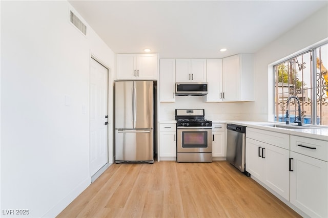 3309 Marionette Ave, Las Vegas, NV 89101 - kitchen featuring stainless steel appliances, light wood-style floors, white cabinets, light countertops, and recessed lighting