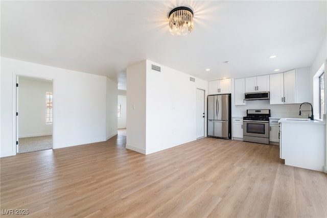 3309 Marionette Ave, Las Vegas, NV 89101 - kitchen with stainless steel appliances, light countertops, light wood-style flooring, white cabinetry, and recessed lighting