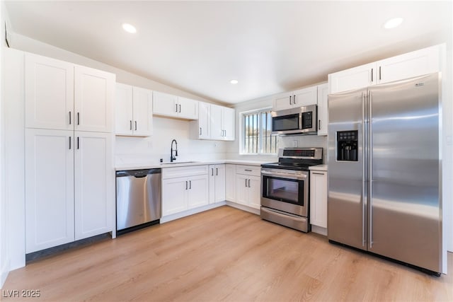 2878 El Cajon St, Las Vegas, NV 89169 - kitchen with stainless steel appliances, white cabinetry, light wood-style floors, light countertops, and recessed lighting