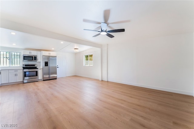 2878 El Cajon St, Las Vegas, NV 89169 - unfurnished living room with plenty of natural light, light wood-type flooring, ceiling fan, recessed lighting, and lofted ceiling