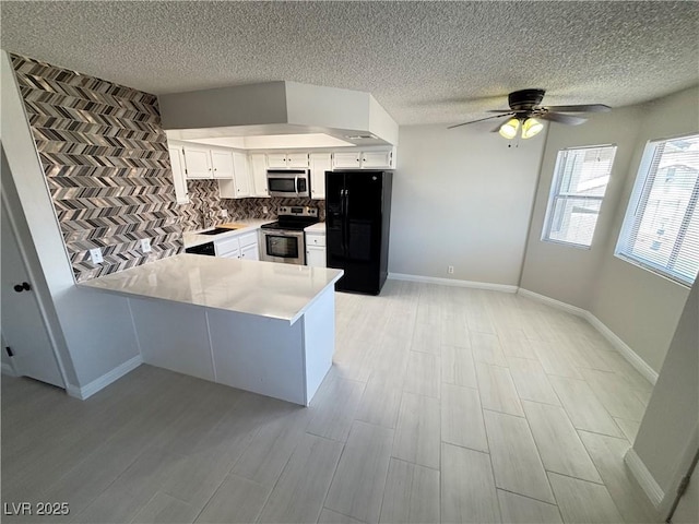 435 Mesa Blvd Unit 202, Mesquite, NV 89027 - kitchen featuring stainless steel appliances, a peninsula, decorative backsplash, light countertops, and white cabinets