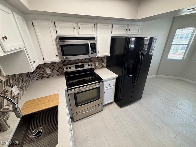 435 Mesa Blvd Unit 202, Mesquite, NV 89027 - kitchen featuring appliances with stainless steel finishes, decorative backsplash, white cabinetry, and light wood-style floors