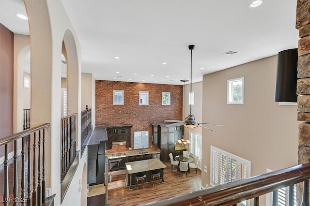 7033 Twin Forks Peak St, Las Vegas, NV 89166 - hallway with arched walkways, recessed lighting, wood finished floors, and brick wall