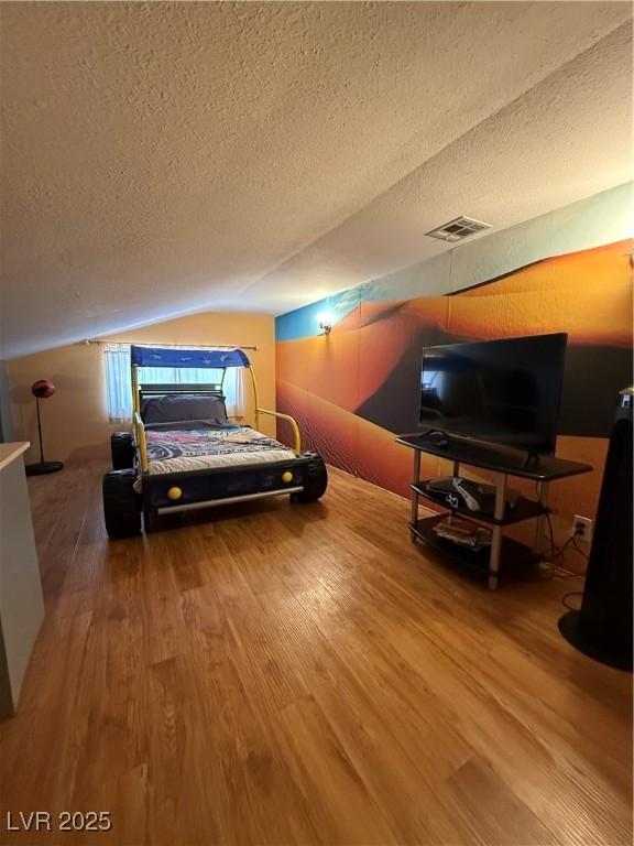 5260 N Jones Blvd, Las Vegas, NV 89130 - bedroom with wood finished floors, a textured ceiling, and vaulted ceiling