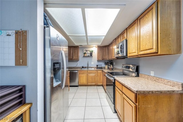 224 Catalini St, Las Vegas, NV 89107 - kitchen with stainless steel appliances, light tile patterned floors, light countertops, and brown cabinetry