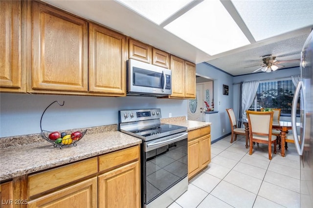 224 Catalini St, Las Vegas, NV 89107 - kitchen with stainless steel appliances, light countertops, light tile patterned floors, a ceiling fan, and a textured ceiling