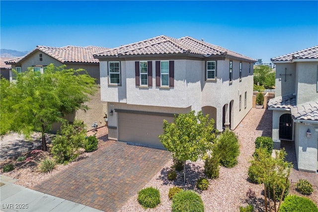 9136 Cocowoods Pl, Las Vegas, NV 89148 - mediterranean / spanish home with stucco siding, a tiled roof, an attached garage, and decorative driveway