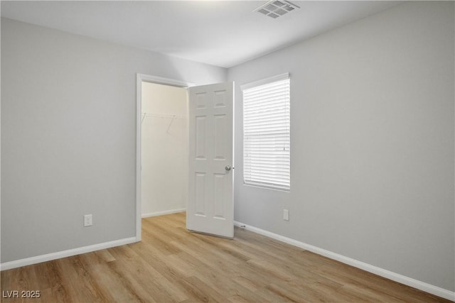 9136 Cocowoods Pl, Las Vegas, NV 89148 - unfurnished bedroom with light wood-type flooring, a closet, and a walk in closet