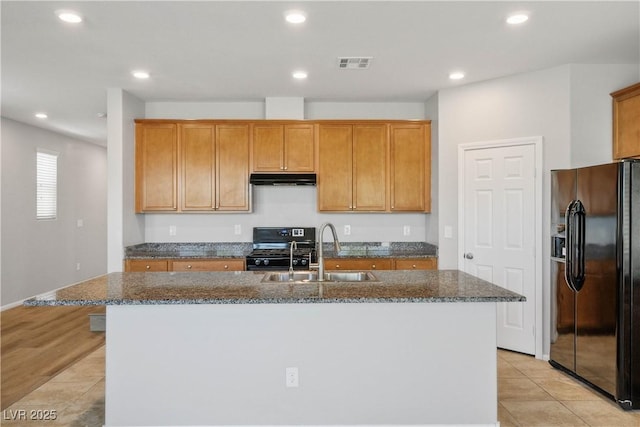9136 Cocowoods Pl, Las Vegas, NV 89148 - kitchen featuring black appliances, under cabinet range hood, dark stone counters, a kitchen island with sink, and recessed lighting