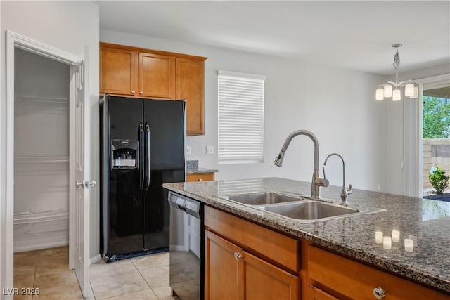 9136 Cocowoods Pl, Las Vegas, NV 89148 - kitchen with black refrigerator with ice dispenser, dishwashing machine, brown cabinets, dark stone countertops, and decorative light fixtures