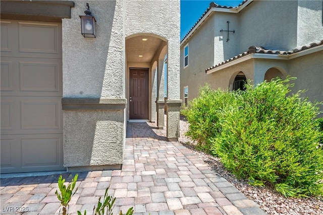 9136 Cocowoods Pl, Las Vegas, NV 89148 - doorway to property featuring stucco siding, a garage, and a tile roof