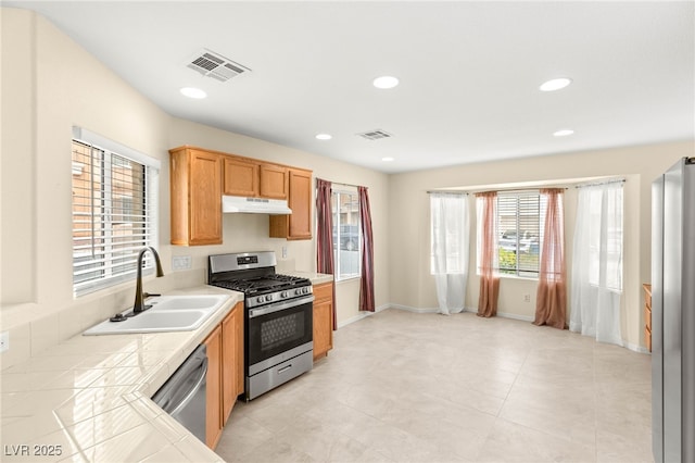 10437 Coyote Cub Ave, Las Vegas, NV 89129 - kitchen with stainless steel appliances, tile counters, under cabinet range hood, and recessed lighting
